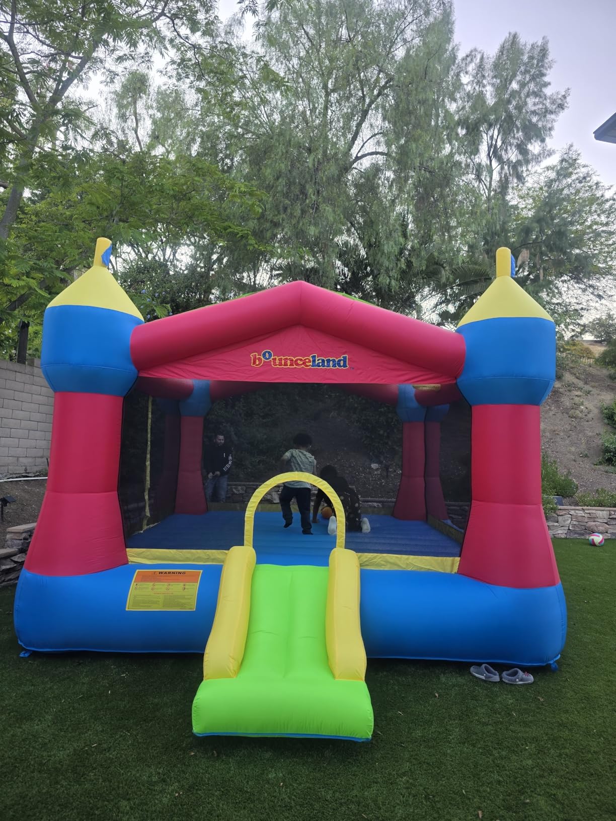 Bounceland Inflatable Party Castle Bounce House Bouncer, 16 ft L x 13 ft W x 10.3 ft H, Basketball Hoop, Removable Sun Roof, UL Strong Blower included, Fun Slide and Bounce Area, Castle Theme for Kids customer photo 1